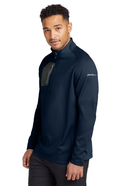 Man wearing a navy blue jacket with a brand logo on a white background. Eddie Bauer® 1/2-Zip Performance Fleece, Embroidered