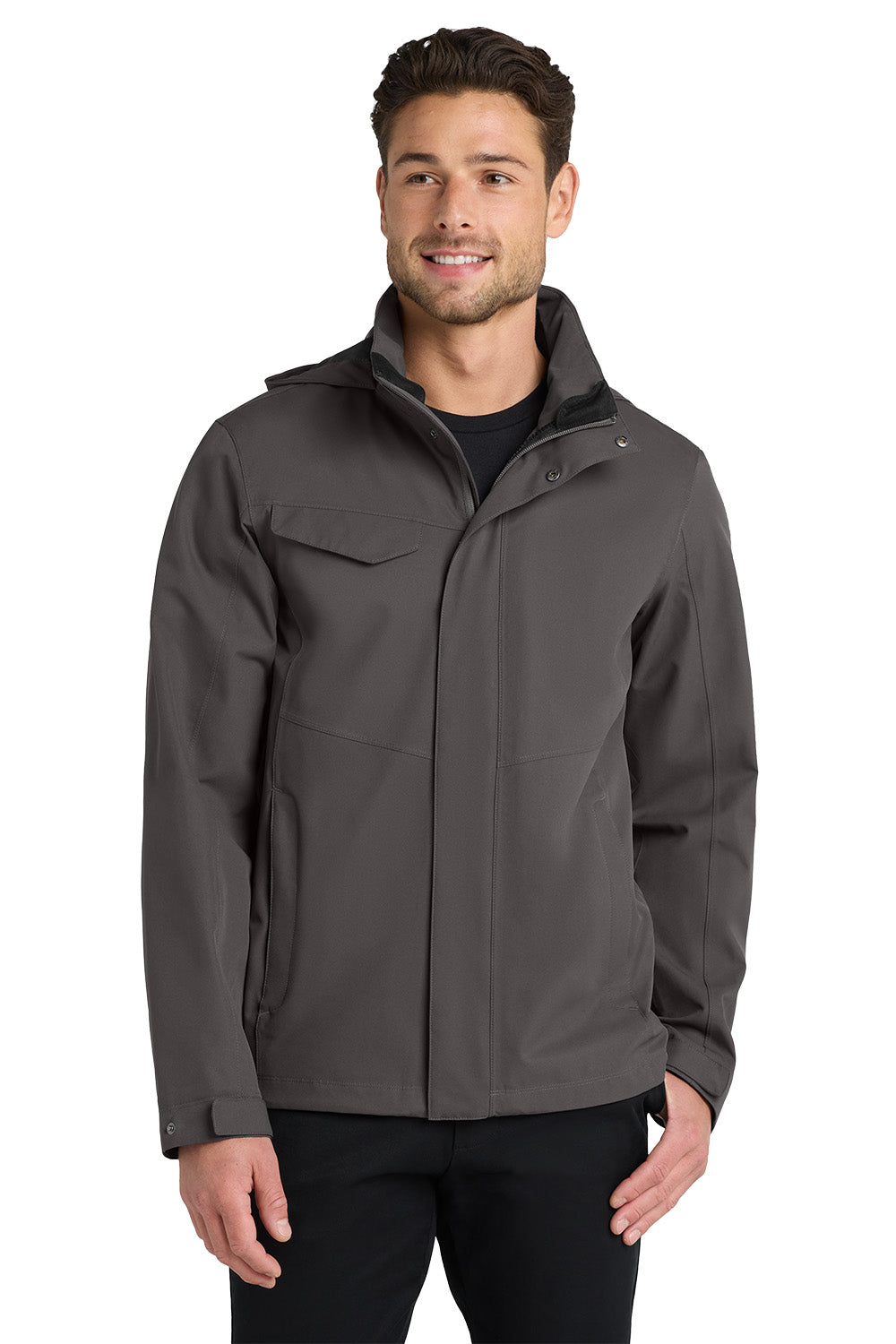 A man wearing a dark gray zip-up jacket over a black shirt and black pants, standing against a plain white background. Port Authority® Collective Outer Shell Jacket, Embroidered