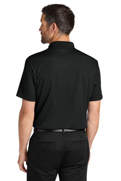 Man wearing a black polo shirt and pants on a white background. Port Authority® Plaited Pique Polo, Embroidered by Helmsman Stitch Co.