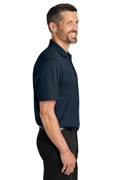 Man wearing a navy polo shirt on a white background. Port Authority® Plaited Pique Polo, Embroidered by Helmsman Stitch Co.