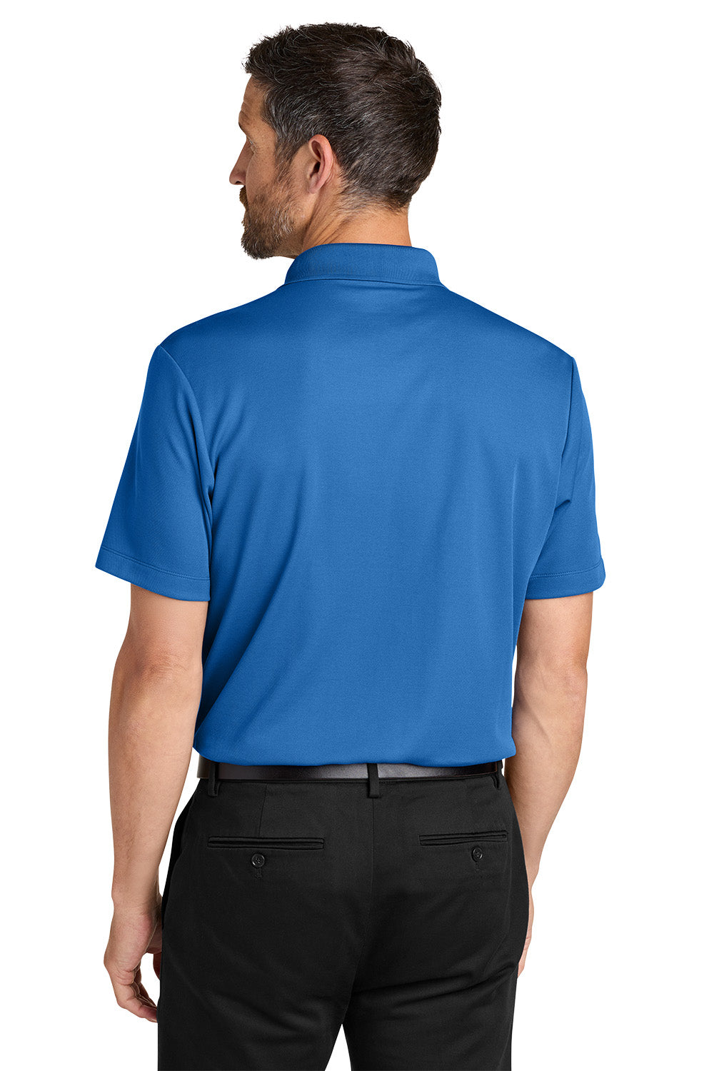 Man wearing a blue polo shirt and black pants on a white background. Port Authority® Plaited Pique Polo, Embroidered by Helmsman Stitch Co.