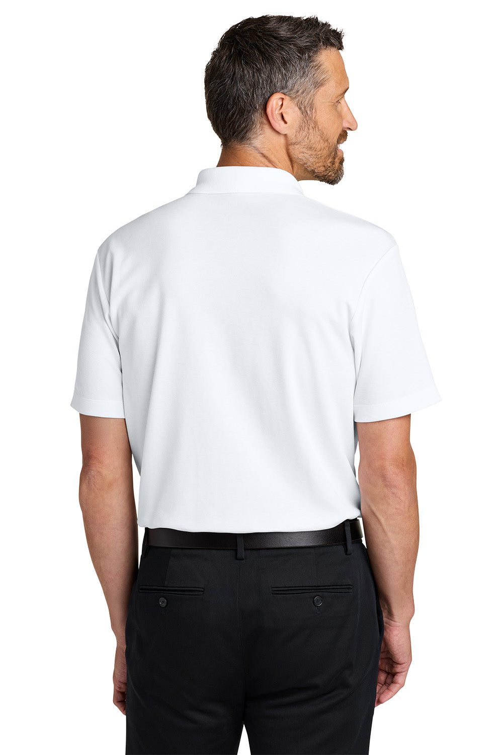 Man wearing a white polo shirt and black pants on a white background. Port Authority® Plaited Pique Polo, Embroidered by Helmsman Stitch Co.