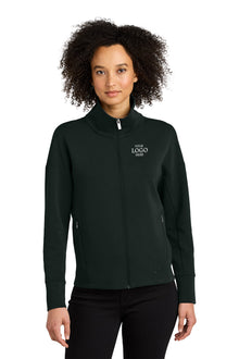 Woman wearing a black jacket with a logo on a white background OGIO® Women’s Transcend Full-Zip, Embroidered
