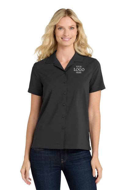 Woman wearing a black short-sleeve shirt with customizable logo text on a white background embroidered Port Authority® Women's Short Sleeve Performance Staff Shirt