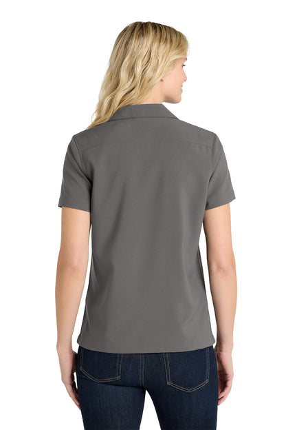 Woman wearing a gray polo shirt on a white background embroidered Port Authority® Women's Short Sleeve Performance Staff Shirt