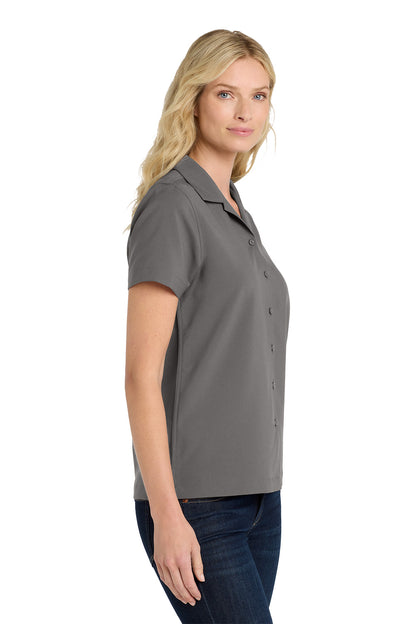 Woman wearing a gray polo shirt on a white background embroidered Port Authority® Women's Short Sleeve Performance Staff Shirt