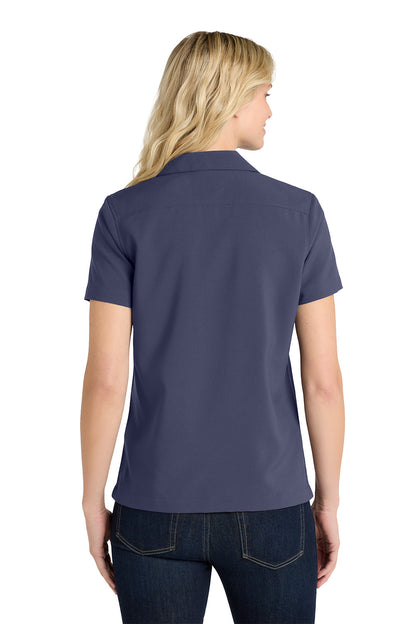 Person wearing a navy blue polo shirt on a white background embroidered Port Authority® Women's Short Sleeve Performance Staff Shirt