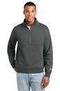 A man wearing a dark gray quarter-zip pullover sweatshirt with a small white New Era logo on the left sleeve, paired with light blue jeans, against a plain white background. New Era® Heritage Fleece 1/2-Zip, Embroidered