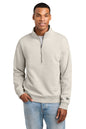 A man wearing a light beige quarter-zip sweatshirt with a mock neck and a horizontal seam across the chest, paired with light blue jeans, against a plain white background.New Era® Heritage Fleece 1/2-Zip, Embroidered