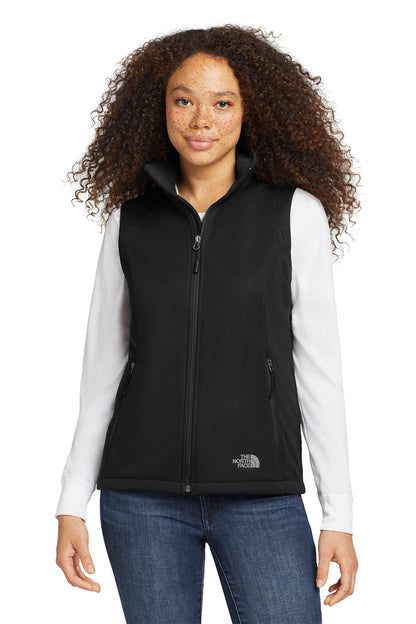 Woman wearing a black vest over a white shirt with a visible brand logo on a white background embroidered The North Face® Women's Ridgewall Soft Shell Vest