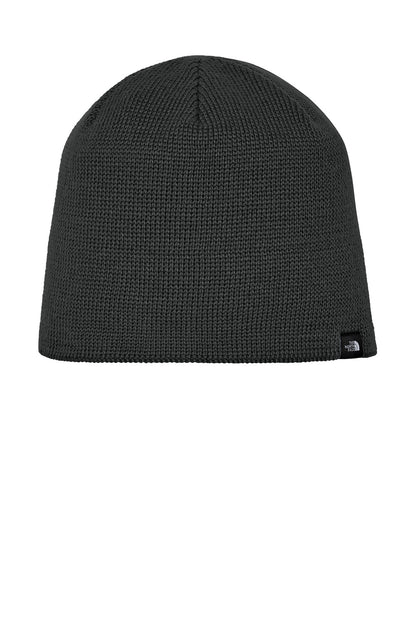 A dark gray ribbed knit beanie hat with a small black embroidered logo of The North Face on the lower right side, shown against a plain white background. The North Face® Mountain Beanie, Embroidered