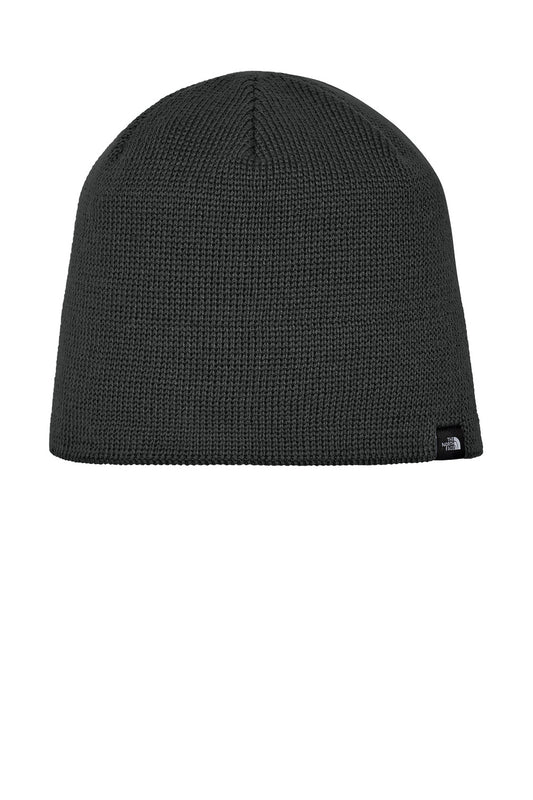 A dark gray ribbed knit beanie hat with a small black embroidered logo of The North Face on the lower right side, shown against a plain white background. The North Face® Mountain Beanie, Embroidered