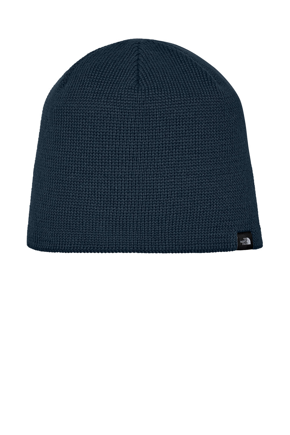 A dark navy blue ribbed knit beanie hat with a small black and white The North Face logo patch on the lower right side, shown against a plain white background. The North Face® Mountain Beanie, Embroidered
