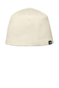 An off-white knit beanie hat with a small black and white The North Face logo patch on the lower right side, shown against a plain white background. The North Face® Mountain Beanie, Embroidered