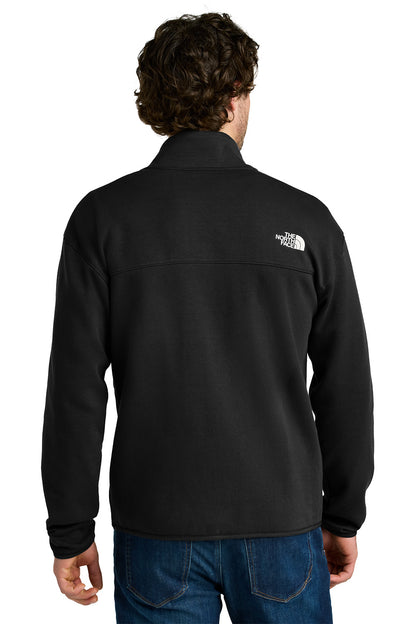 Person wearing a black jacket with a brand logo on the back, standing against a white background embroidered The North Face® Double-Knit 1/2-Zip Fleece