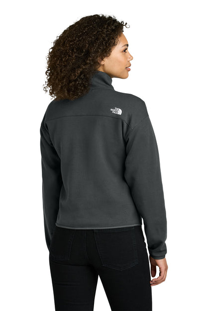 Woman wearing a gray jacket with a brand logo on the back, standing against a white background embroidered The North Face® Women's Double-Knit 1/2-Zip Fleece