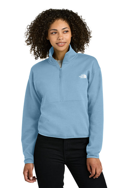 Woman wearing a light blue pullover with a brand logo on a white background embroidered The North Face® Women's Double-Knit 1/2-Zip Fleece
