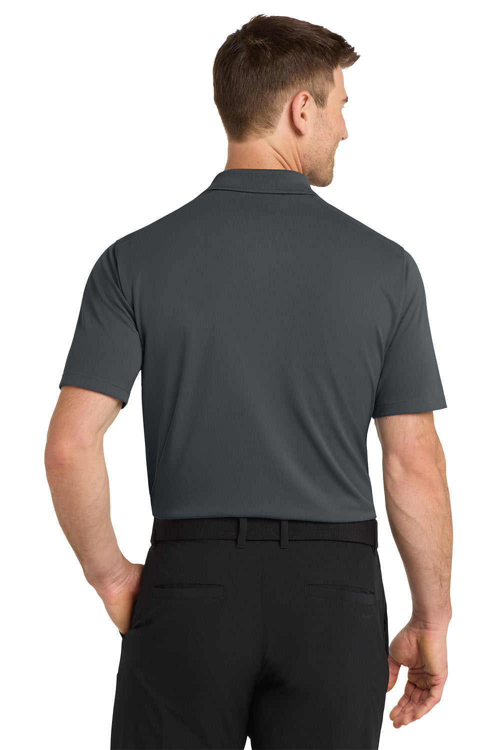 Man wearing a gray polo shirt and black pants on a white background. Nike Dri-FIT Micro Pique 2.0 Polo, Embroidered by Helmsman Stitch Co.