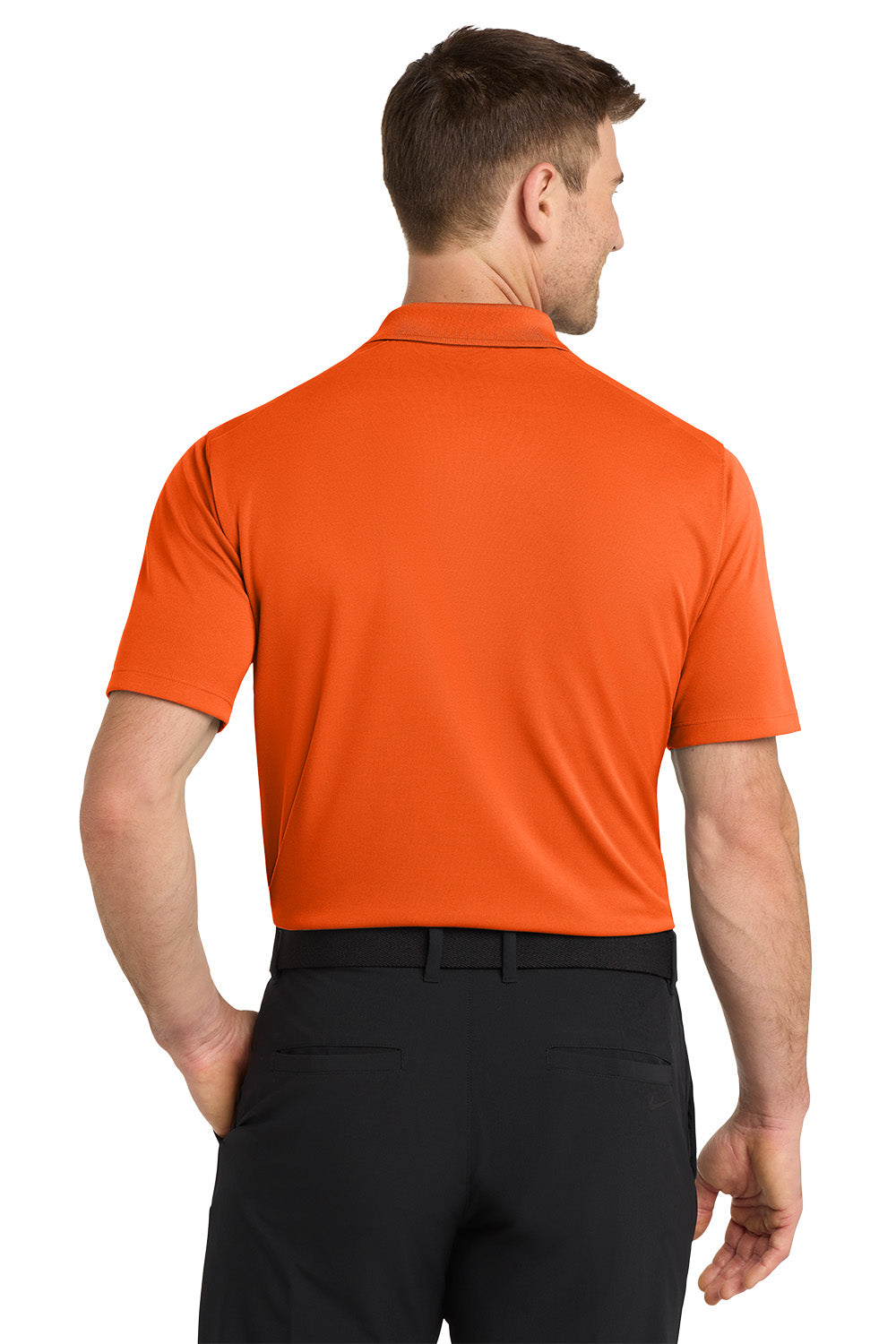 Man wearing an orange polo shirt and black pants on a white background. Nike Dri-FIT Micro Pique 2.0 Polo, Embroidered by Helmsman Stitch Co.