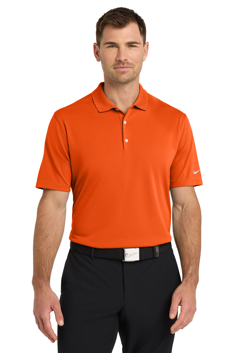 Man wearing an orange Nike polo shirt and black pants on a white background. Nike Dri-FIT Micro Pique 2.0 Polo, Embroidered by Helmsman Stitch Co.