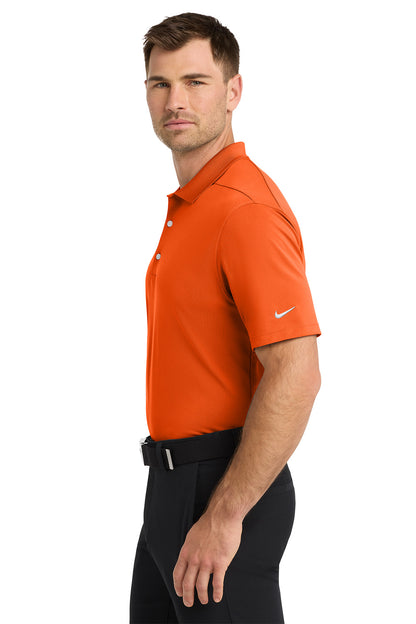 Man wearing an orange Nike polo shirt on a white background. Nike Dri-FIT Micro Pique 2.0 Polo, Embroidered by Helmsman Stitch Co.