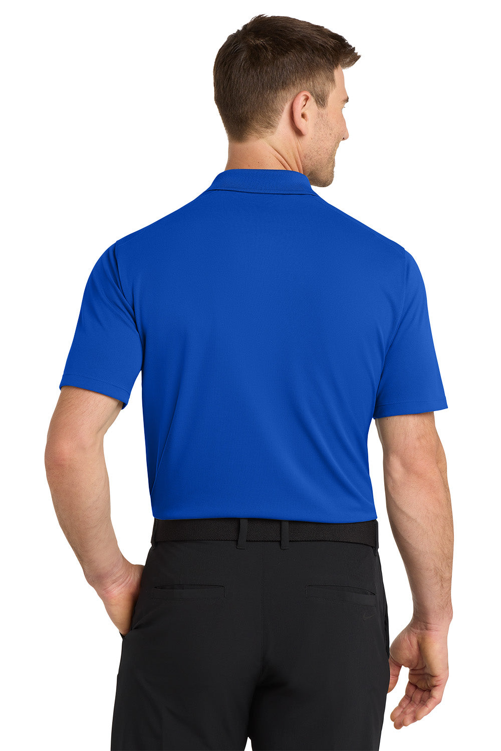 Man wearing a blue polo shirt and black pants on a white background. Nike Dri-FIT Micro Pique 2.0 Polo, Embroidered by Helmsman Stitch Co.