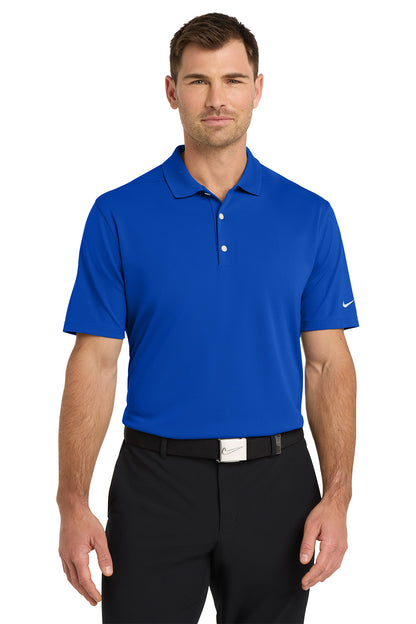 Man wearing a blue Nike polo shirt and black pants on a white background. Nike Dri-FIT Micro Pique 2.0 Polo, Embroidered by Helmsman Stitch Co.
