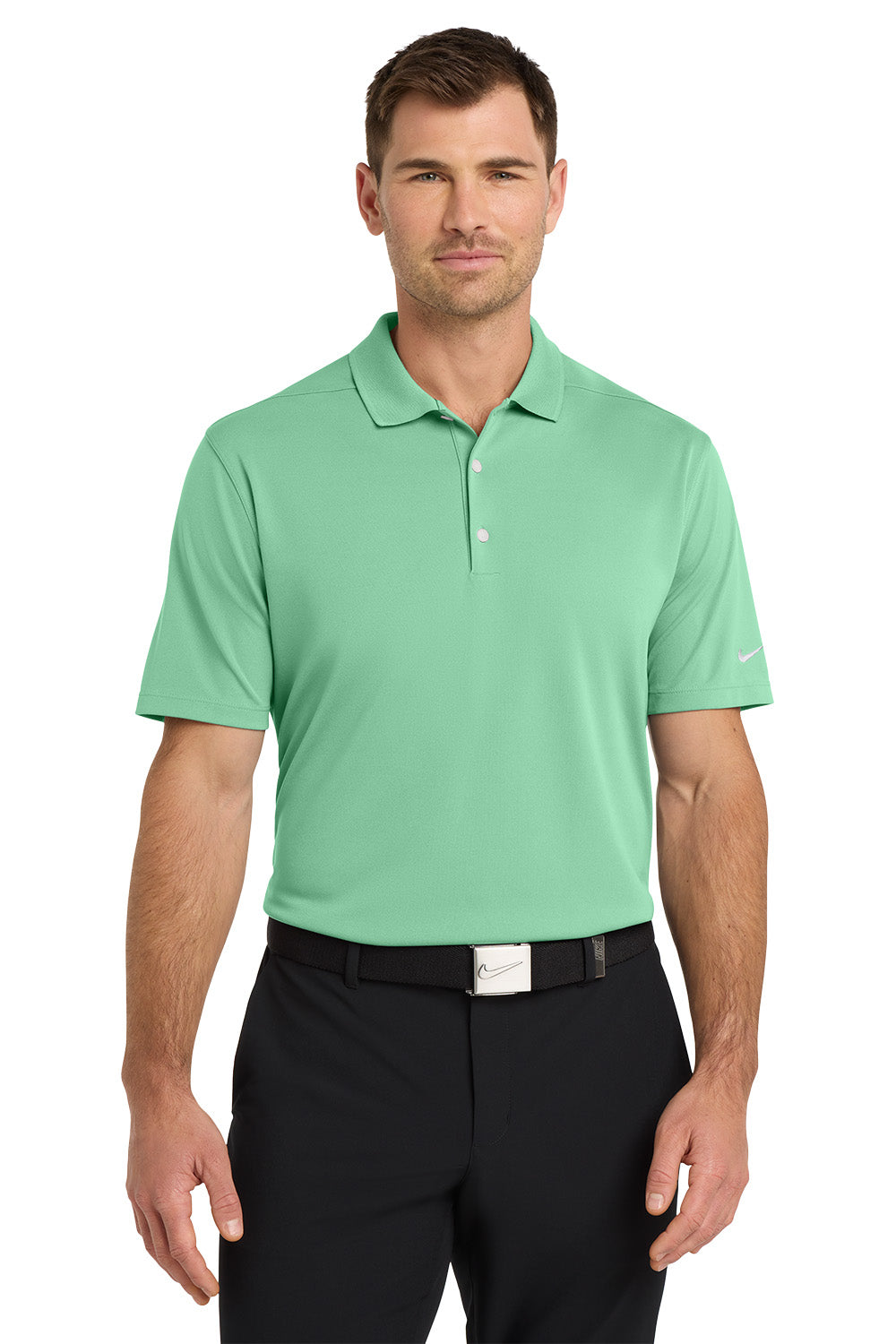 Man wearing a green polo shirt and black pants on a white background. Nike Dri-FIT Micro Pique 2.0 Polo, Embroidered by Helmsman Stitch Co.