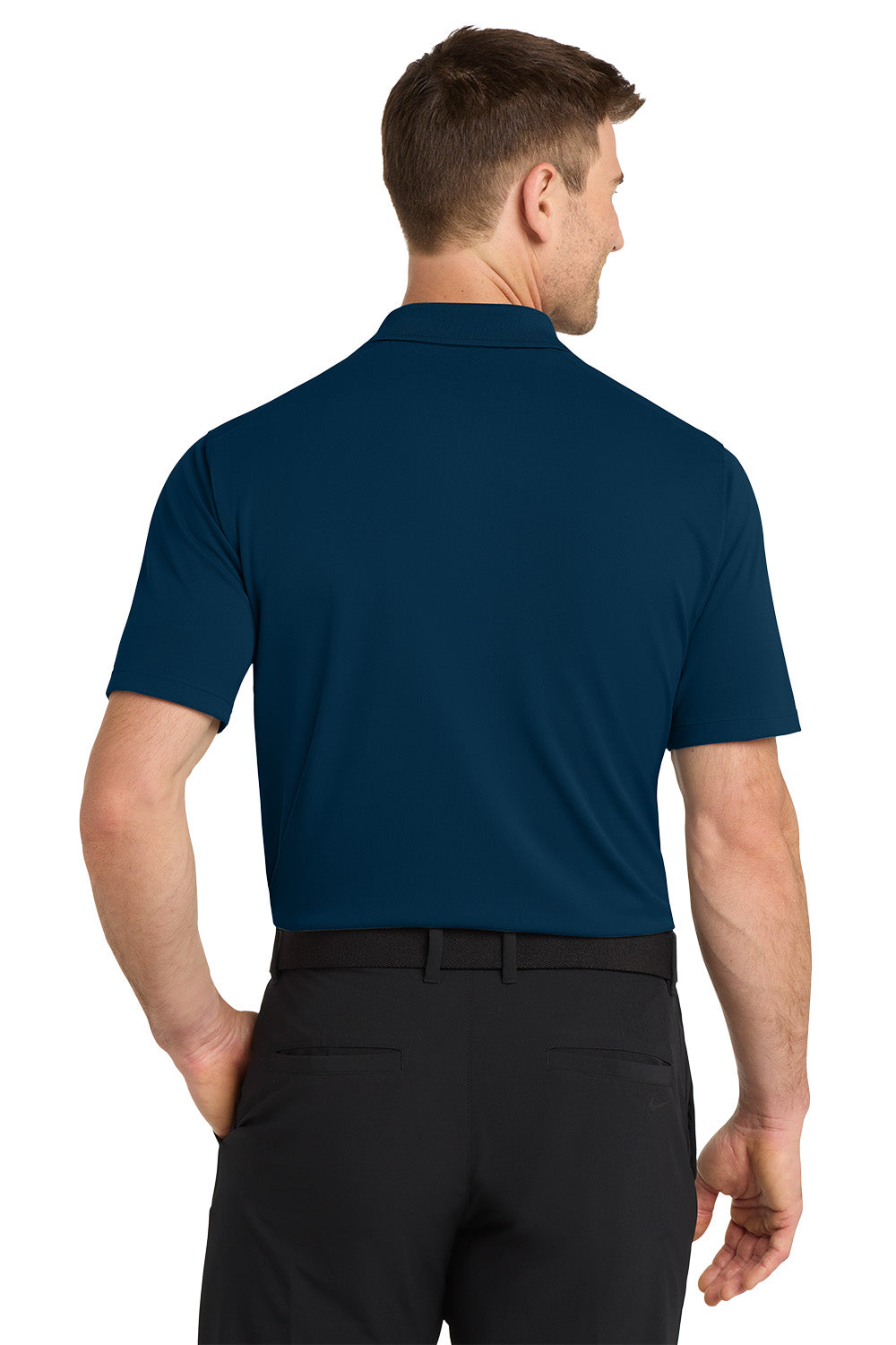 Man wearing a blue polo shirt and black pants on a white background. Nike Dri-FIT Micro Pique 2.0 Polo, Embroidered by Helmsman Stitch Co.
