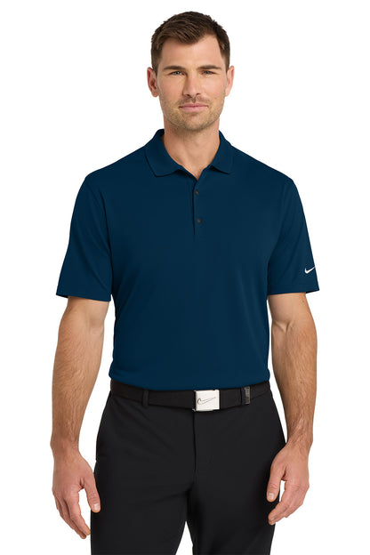 Man wearing a navy blue polo shirt with a Nike logo on a white background. Nike Dri-FIT Micro Pique 2.0 Polo, Embroidered by Helmsman Stitch Co.