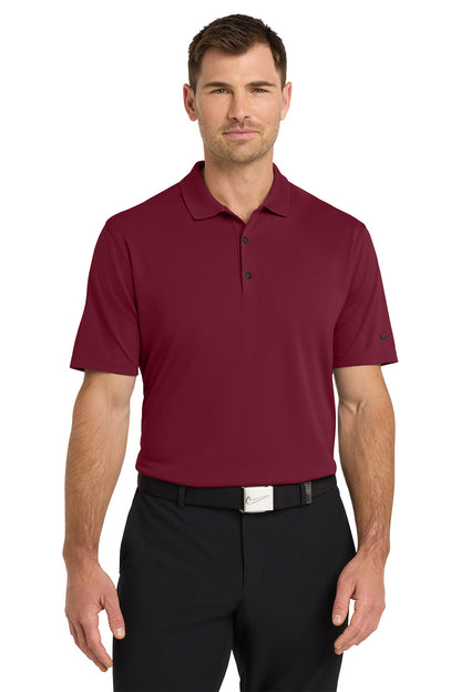 Man wearing a maroon polo shirt and black pants on a white background. Nike Dri-FIT Micro Pique 2.0 Polo, Embroidered by Helmsman Stitch Co.