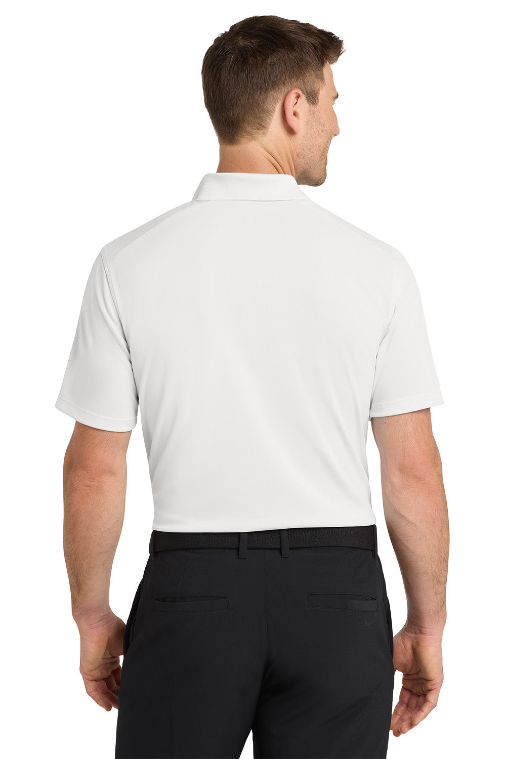 Man wearing a white polo shirt and black pants on a white background. Nike Dri-FIT Micro Pique 2.0 Polo, Embroidered by Helmsman Stitch Co.