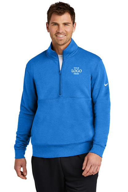 Man wearing a blue quarter-zip sweatshirt with a logo on a white background, Embroidered Nike Club Fleece Sleeve Swoosh 1/2-Zip