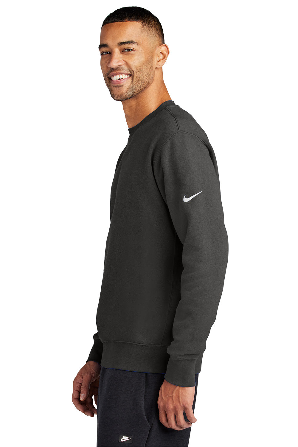 Man wearing a black Nike sweatshirt on a white background, Embroidered Nike Club Fleece Sleeve Swoosh Crew