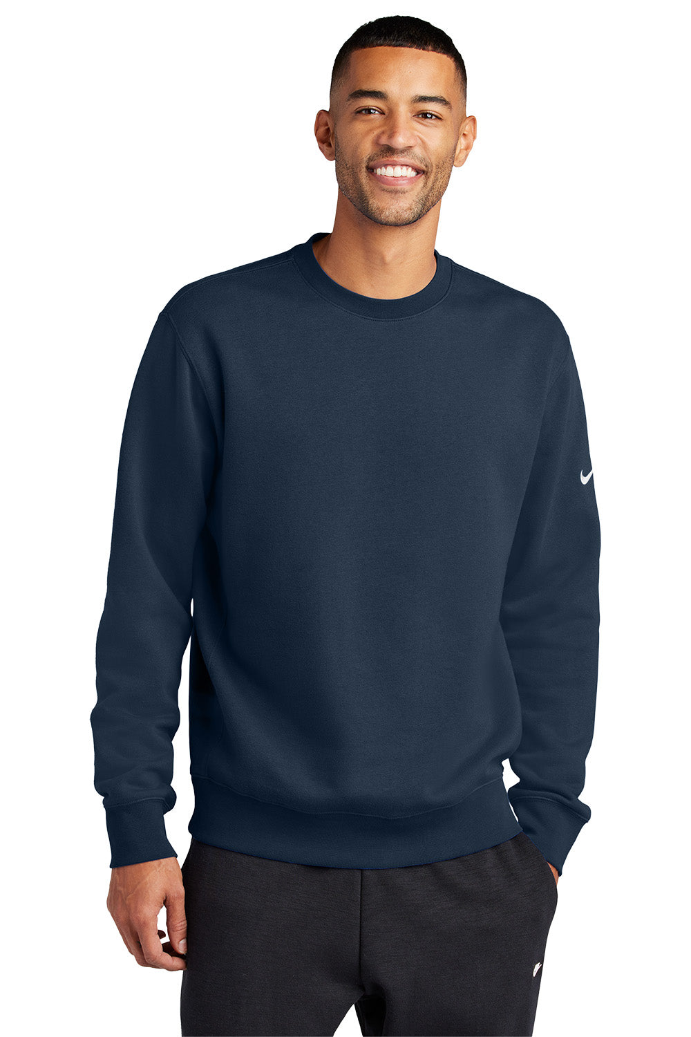 Man wearing a navy blue Nike sweatshirt on a white background, Embroidered Nike Club Fleece Sleeve Swoosh Crew