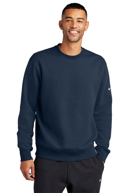 Man wearing a navy blue Nike sweatshirt on a white background, Embroidered Nike Club Fleece Sleeve Swoosh Crew