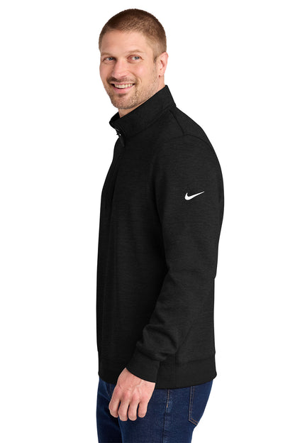 A man wearing a black Nike quarter-zip pullover jacket with a white swoosh logo on the left sleeve, paired with blue jeans, shown from a side profile against a white background. Nike Dri-FIT Corporate 1/2-Zip, Embroidered