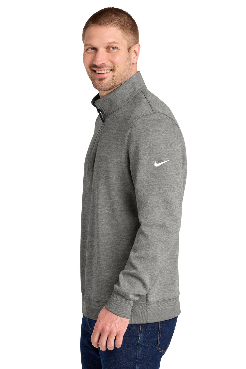 A man wearing a heather gray Nike quarter-zip pullover sweatshirt with a white swoosh logo on the left sleeve, paired with blue jeans, shown against a plain white background. Nike Dri-FIT Corporate 1/2-Zip, Embroidered