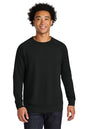 A man wearing a plain black long-sleeve crewneck sweatshirt, paired with dark blue jeans, standing against a solid white background. Next Level Apparel® Laguna Raglan Sweatshirt, Embroidered
