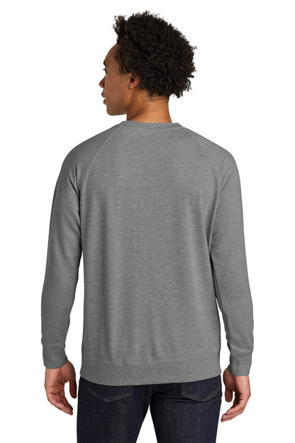 Person wearing a gray long-sleeve shirt on a white background. Next Level Apparel® Laguna Raglan Sweatshirt, Embroidered