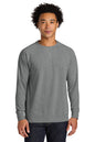 A man wearing a heather gray long-sleeve crewneck sweatshirt, paired with dark blue jeans, standing against a plain white background. Next Level Apparel® Laguna Raglan Sweatshirt, Embroidered
