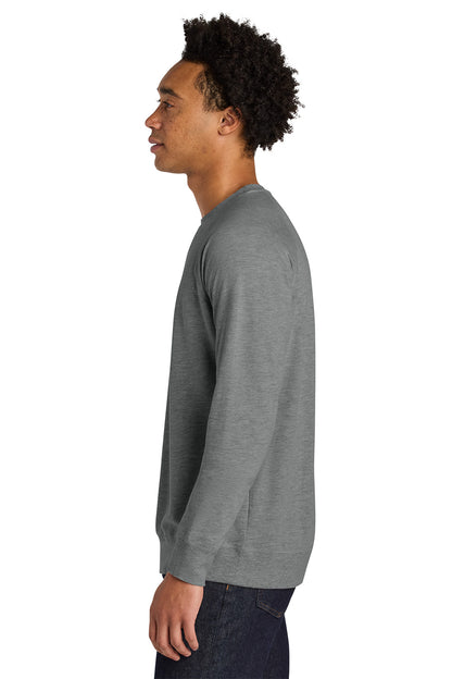 A man shown in profile wearing a heather gray long-sleeve crewneck sweatshirt and dark jeans against a plain white background. Next Level Apparel® Laguna Raglan Sweatshirt, Embroidered