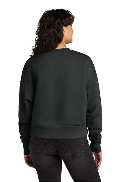 A woman viewed from the back wearing a dark charcoal gray crewneck sweatshirt and dark jeans against a plain white background. Next Level Apparel® Women’s Heavyweight Sweatshirt, Embroidered