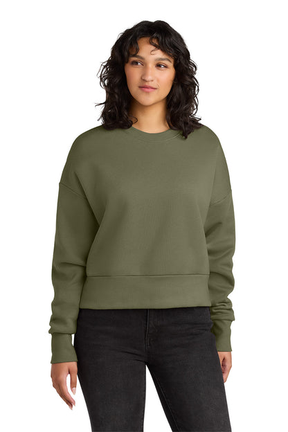 Woman wearing an olive green sweatshirt on a white background. Next Level Apparel® Women’s Heavyweight Sweatshirt, Embroidered
