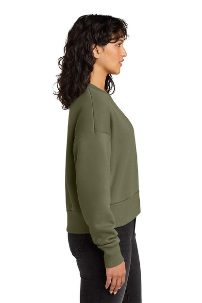 Woman wearing an olive green sweatshirt on a white background. Next Level Apparel® Women’s Heavyweight Sweatshirt, Embroidered