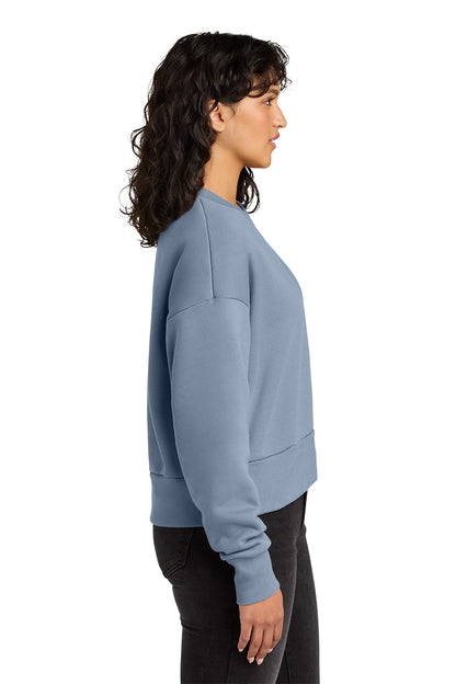 Woman wearing a light blue sweatshirt on a white background. Next Level Apparel® Women’s Heavyweight Sweatshirt, Embroidered