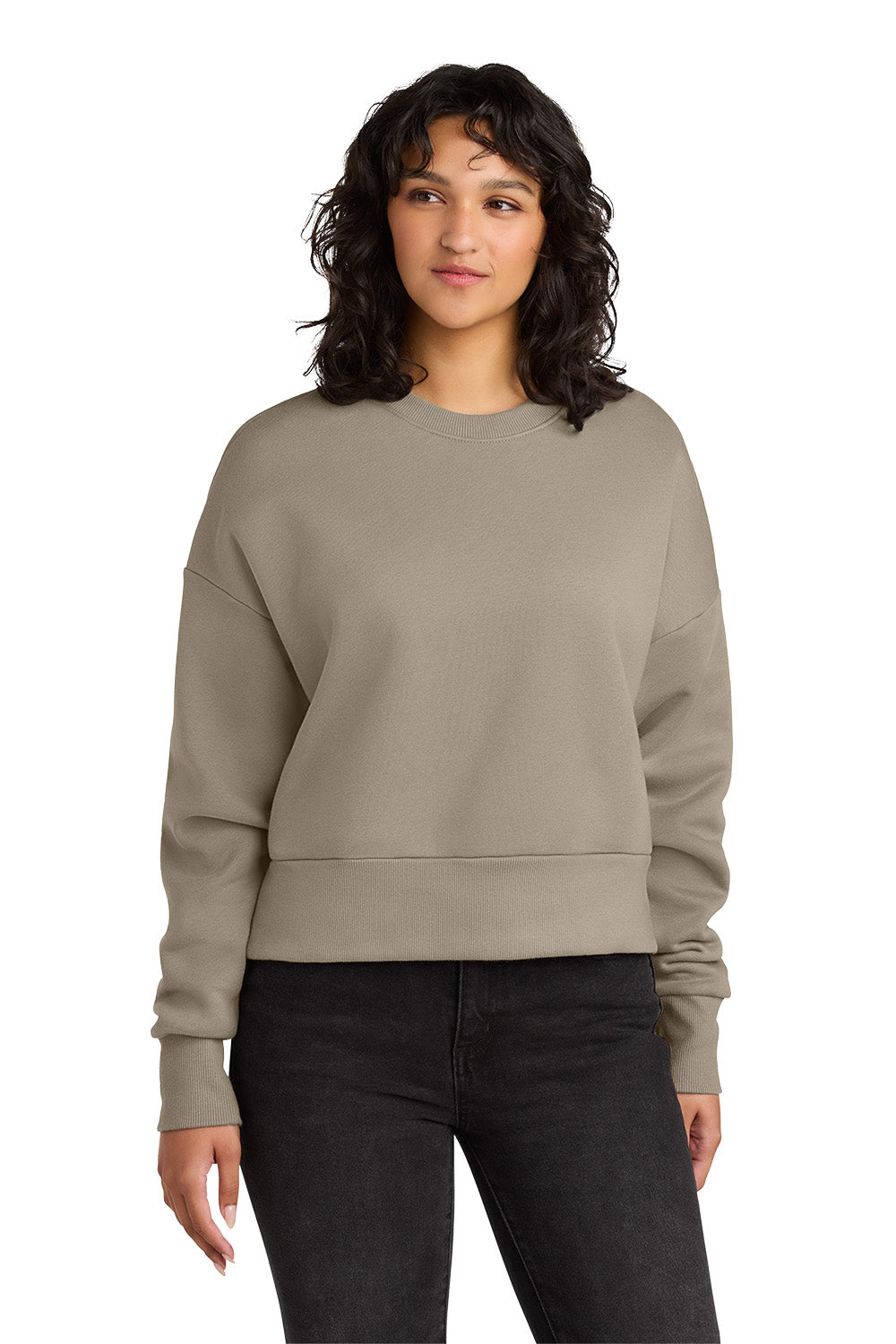 Woman wearing a beige sweatshirt and black pants on a white background. Next Level Apparel® Women’s Heavyweight Sweatshirt, Embroidered