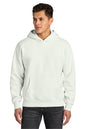 A man wearing a light off-white pullover hoodie with a front kangaroo pocket, paired with dark gray jeans, photographed against a solid white background.  Next Level Apparel® Heavyweight Hoodie, Embroidered