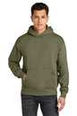 A man wearing an olive green pullover hoodie with a kangaroo pocket, paired with dark gray jeans, against a plain white background. Next Level Apparel® Heavyweight Hoodie, Embroidered