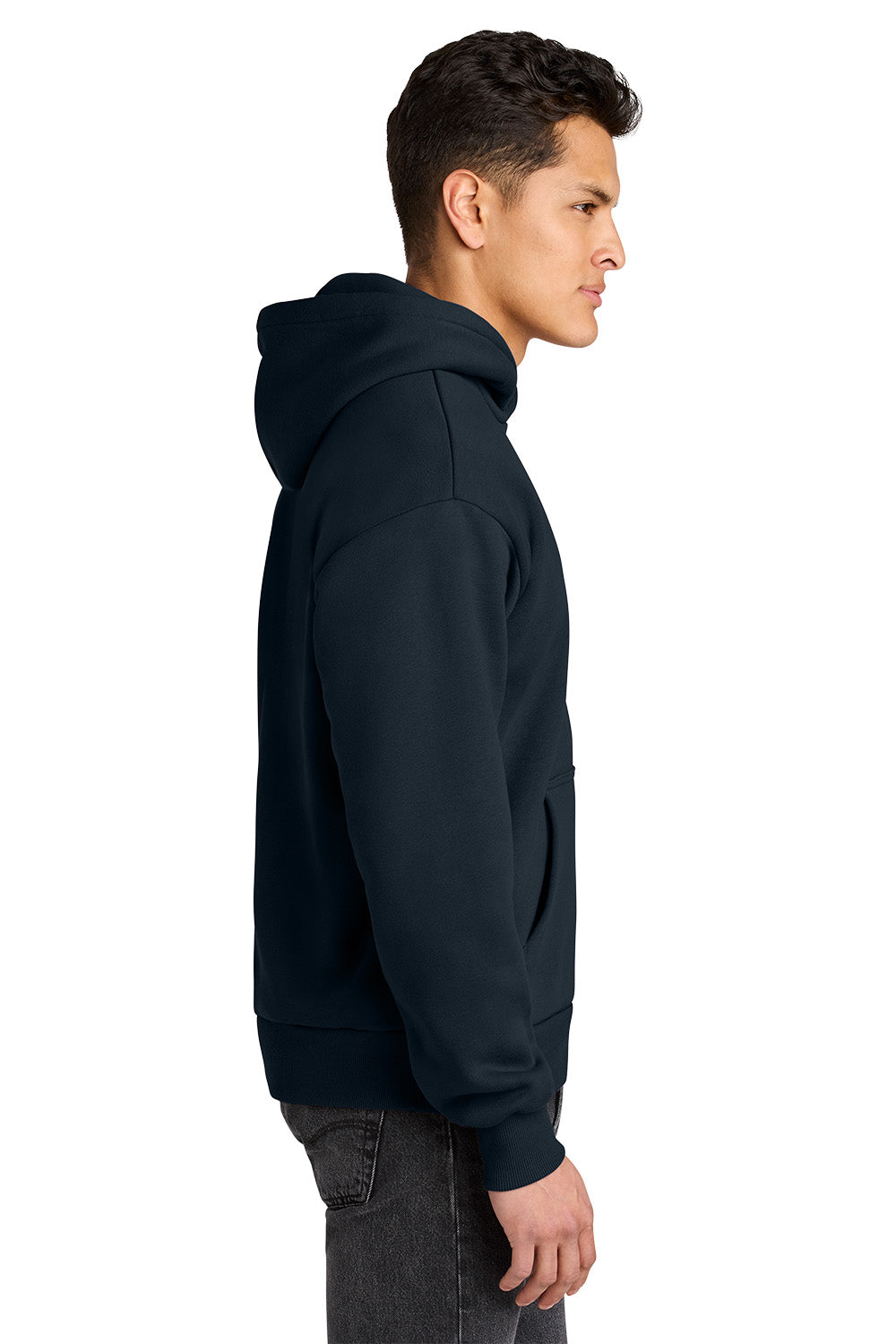 A man shown in profile wearing a dark navy pullover hoodie and dark gray jeans against a plain white background. Next Level Apparel® Heavyweight Hoodie, Embroidered